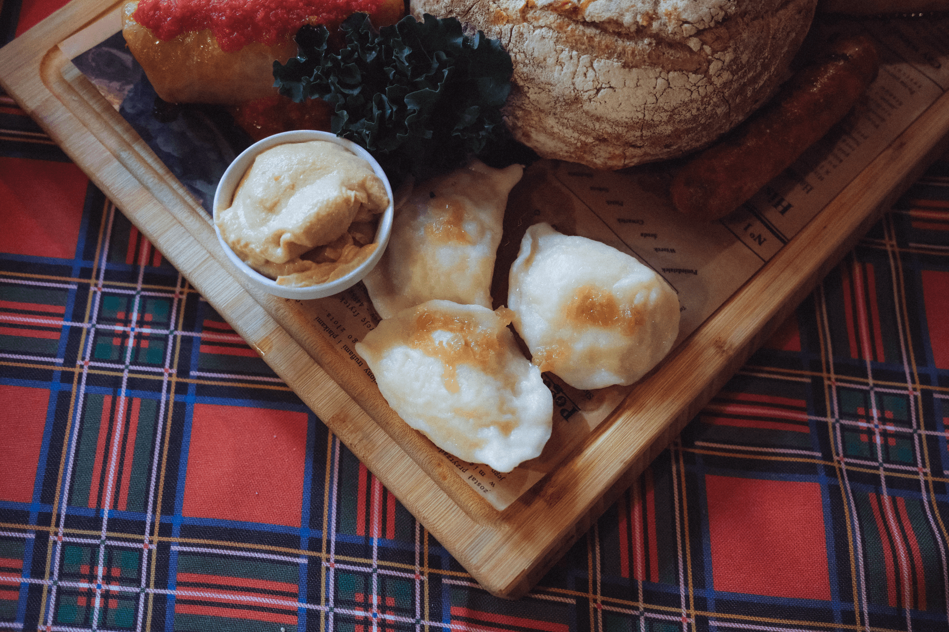 Pierogi, chleb i kiełbasy na drewnianej desce w podkarpackim klimacie